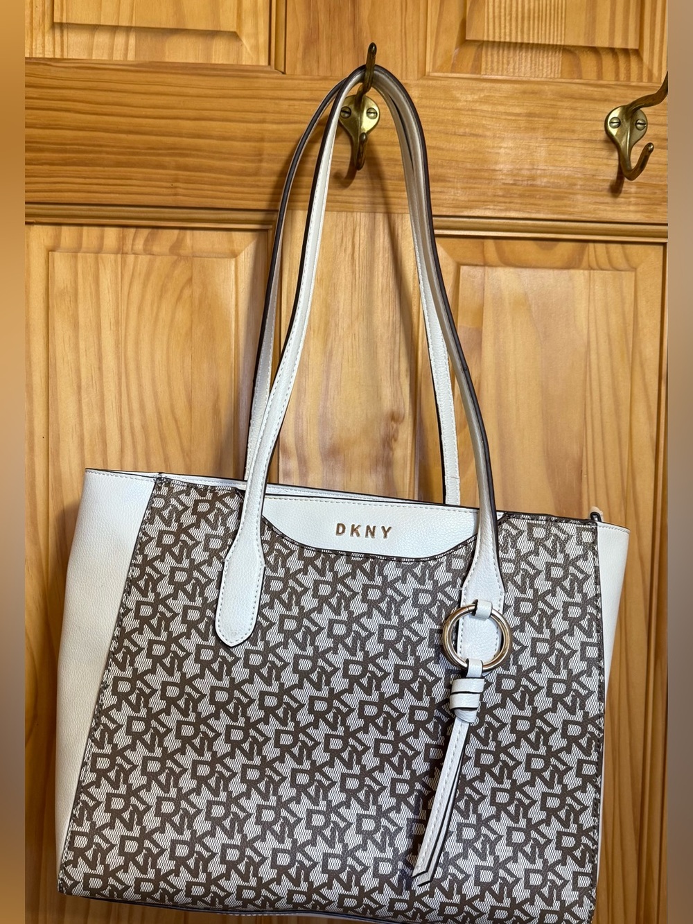 DKNY White and Brown Monogrammed Tote with Gold Ring Accent.
12”W 10.5”Tall X4”D